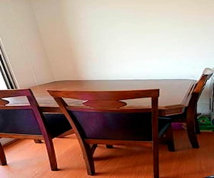 <p>Mesa de madera con cuatro sillas</p>